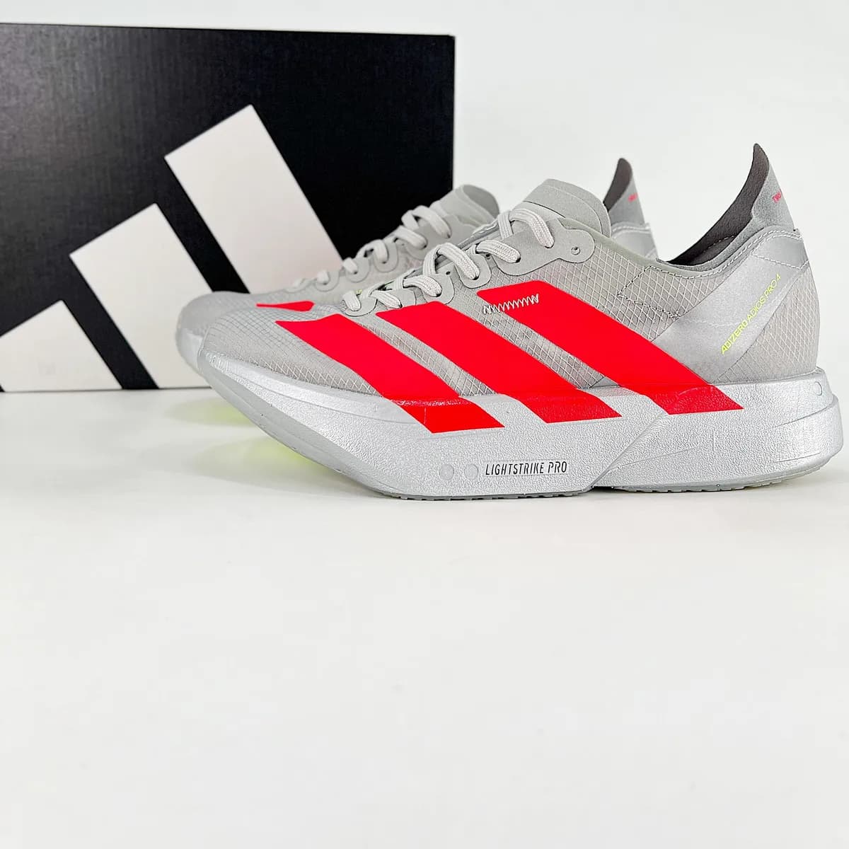 Adizero Adios Pro cinza e vermelho, ângulo 1 de 3